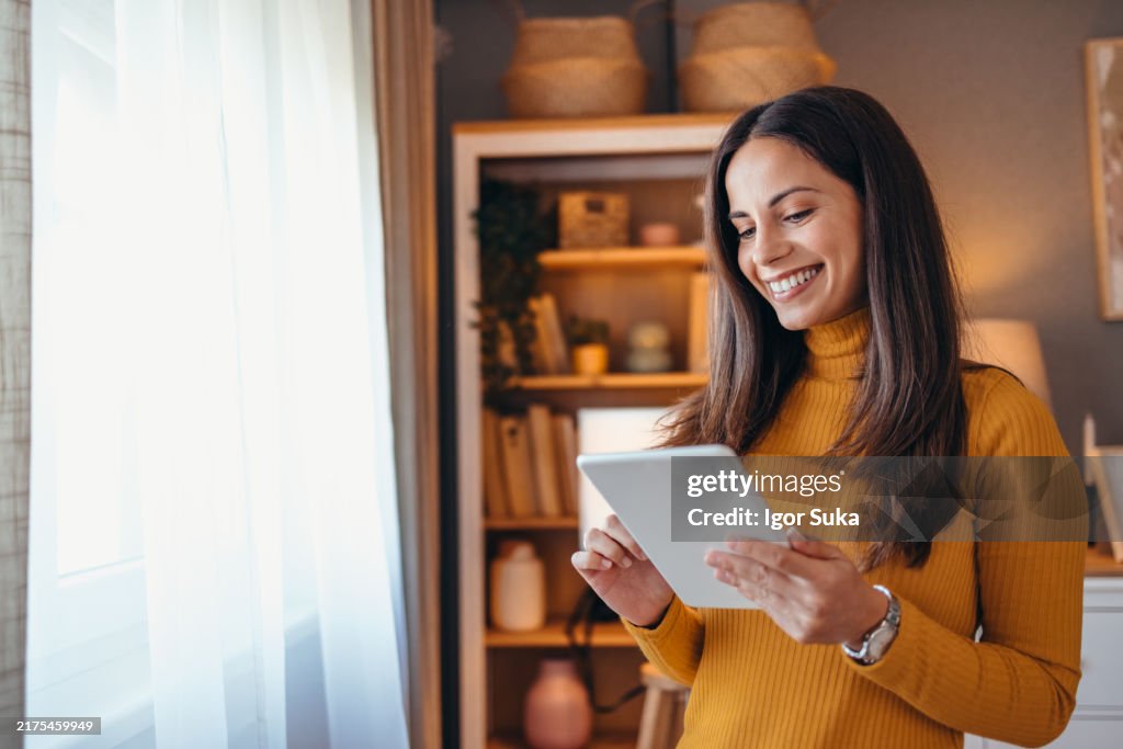 Smiling Woman Using Tablet in Cozy Living Room Setting