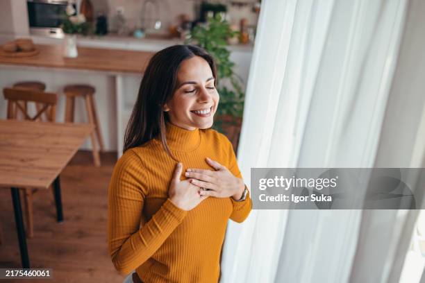 woman in cozy home enjoying a moment of gratitude - self-love stock pictures, royalty-free photos & images