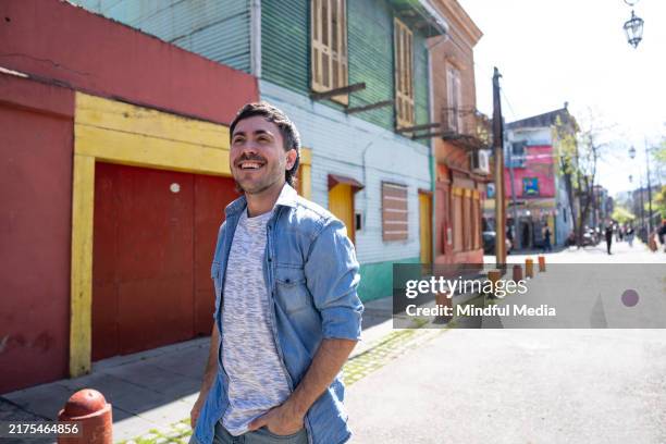 young man taking a walk in the streets of la boca, buenos aires, argentina - buenos aires tourist stock pictures, royalty-free photos & images
