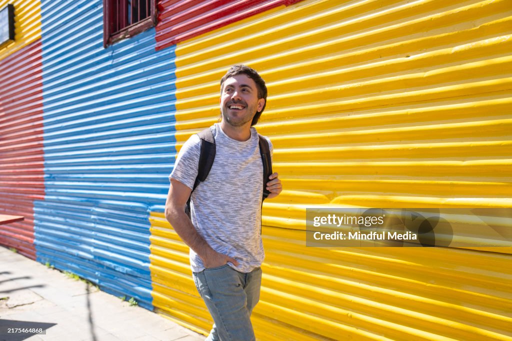 Young man taking a walk in the colorful streets of La Boca, Buenos Aires, Argentina