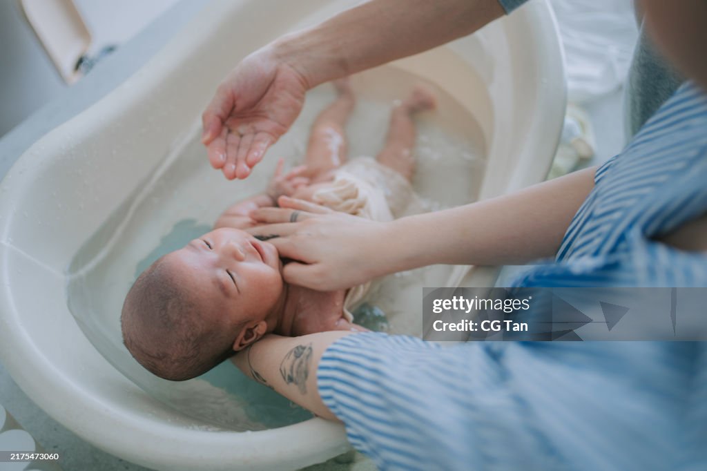Crying asian baby girl in baby bathtub