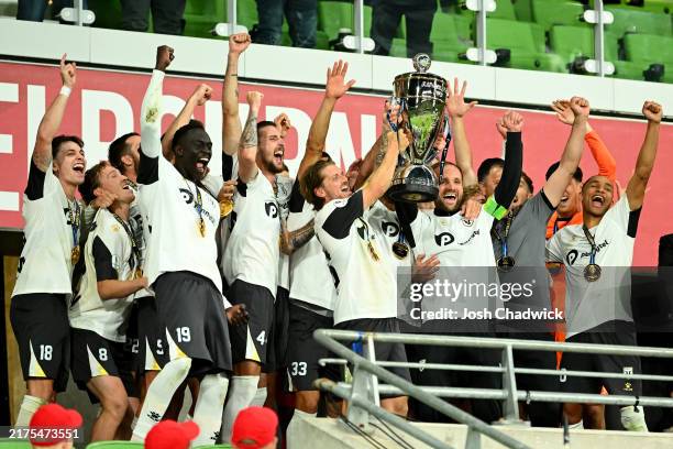 Macarthur FC hold the trophy aloft after winning the 2024 Australia Cup Final match between Melbourne Victory and Macarthur FC at AAMI Park on...