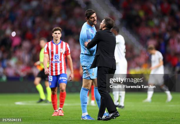 Thibaut Courtois of Real Madrid interacts with Diego Simeone, Head Coach of Atletico de Madrid, during the LaLiga match between Atletico de Madrid...