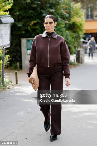 Deborah Reyner Sebag wears burgundy jacket with leather collar, burgundy trousers, beige bag, outside Hermes, during Womenswear Spring/Summer 2025 as...
