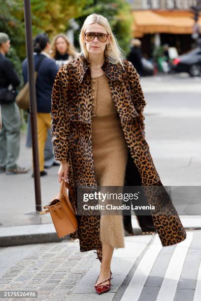 Guest wears beige crop sweater, matching long skirt, leopard print coat, beige Hermes bag, burgundy heels, outside Hermes, during Womenswear...