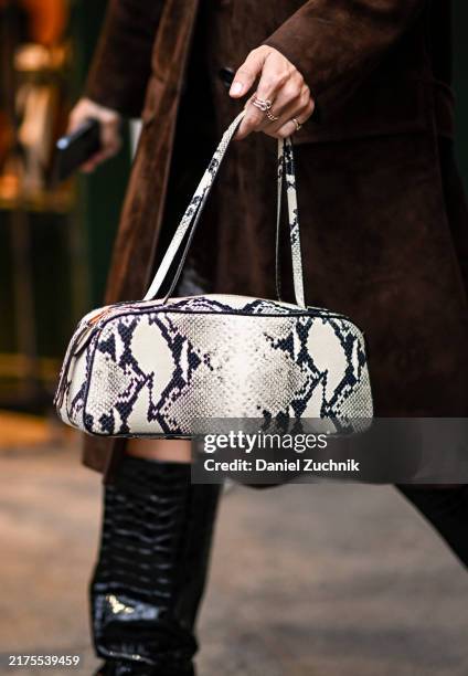 Guest wearing a brown coat, black knee high boots and snakeskin bag outside the Isabel Marant show during Womenswear Spring/Summer2025 as part of...