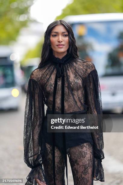 Pritika Swarup wears black sheer mesh lace long sleeve flared jumpsuit, black mini shorts, outside Nina Ricci, during the Paris Fashion Week...