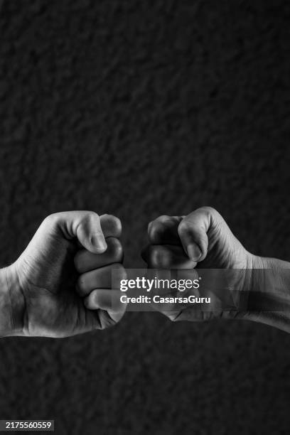 outstretched fist bumps against each other - hand punch stock pictures, royalty-free photos & images