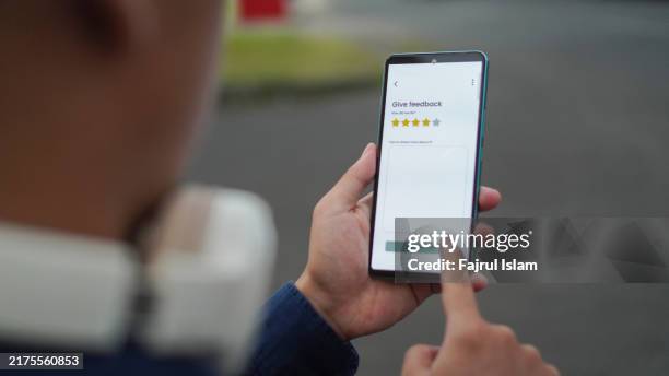 person holding smart phone with restaurant rating app - feedback foto e immagini stock