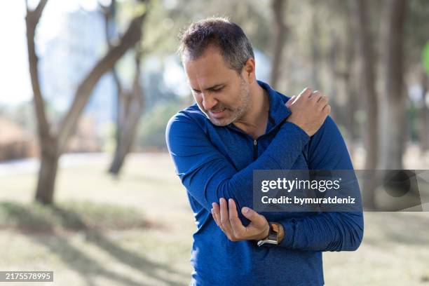 man having pain during her workout and showing negative emotion - elbow stock pictures, royalty-free photos & images