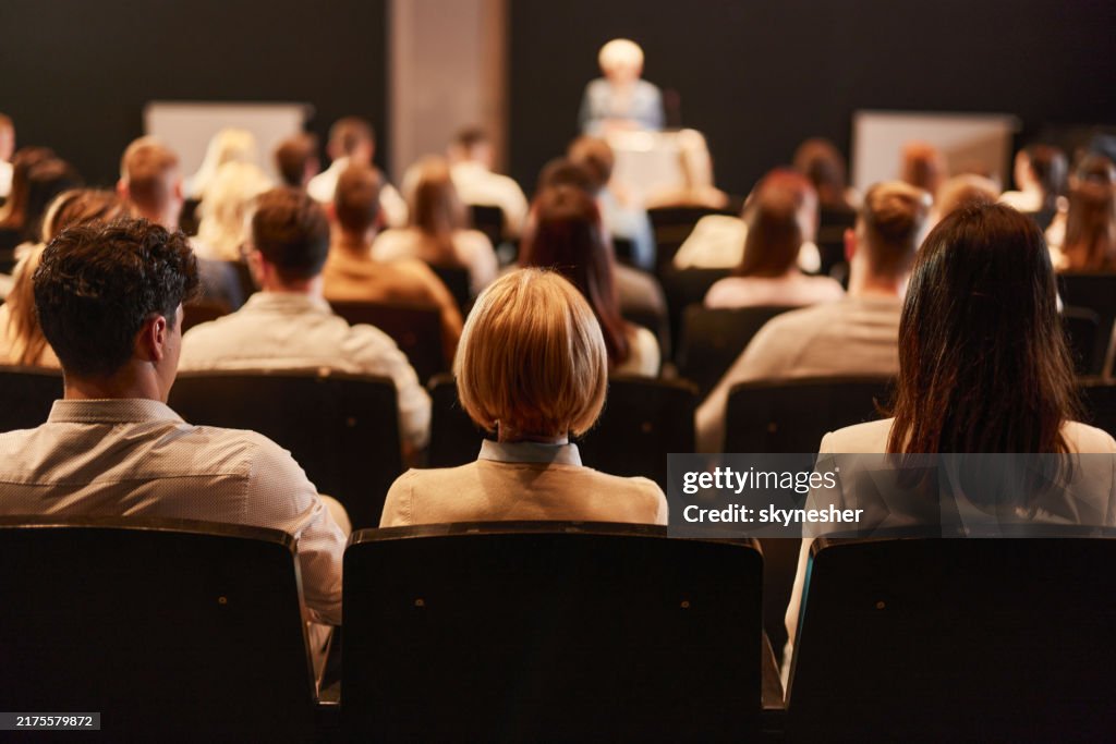 Back view of crowd of people on a seminar in convention center.