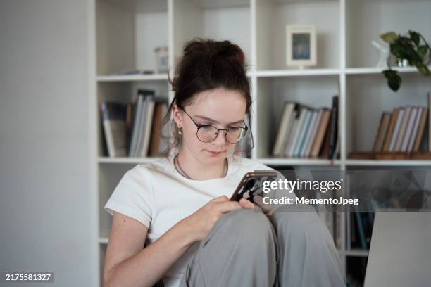 teenagers and screen time. teen girl using mobile phone looking at smartphone screen chatting online, scrolling on social media, feeling sad - screen time stock pictures, royalty-free photos & images
