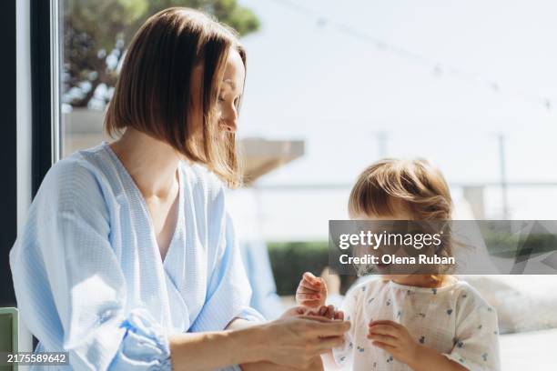 young woman playing with her daughter in a bright day. - home sweet home stock pictures, royalty-free photos & images