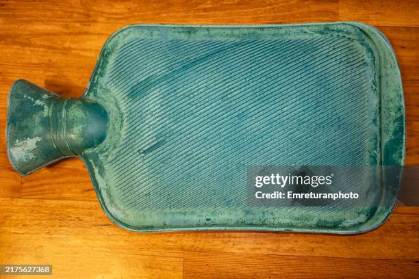 close up of hot water bottle on a wooden surface. - wärmflasche stock-fotos und bilder