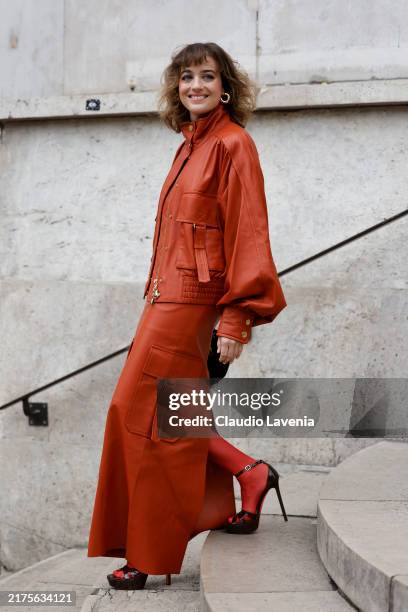Beatrice Grannò wears orange leather jacket matching long skirt, red tights, black heels, outside Zimmermann, during Womenswear Spring/Summer 2025 as...