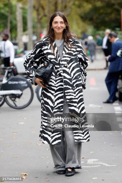 Guest wears black and white zebra print coat, grey jeans, black ballet flats, black bag, outside Zimmermann, during Womenswear Spring/Summer 2025 as...