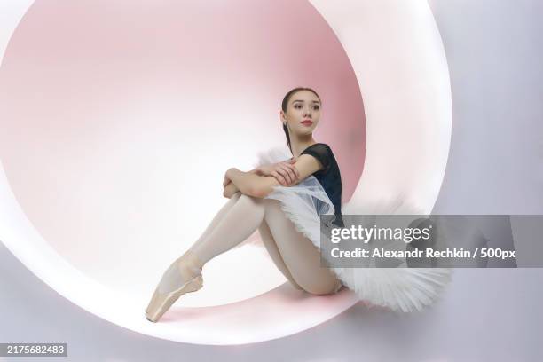 young ballerina in a white tutu sits in a ring set beautiful ballerina,novosibirsk,siberia,russia - trikot stock-fotos und bilder