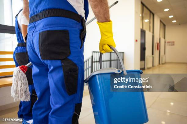 unrecognizable janitors with cleaning equipment in hands - caretaker stock pictures, royalty-free photos & images