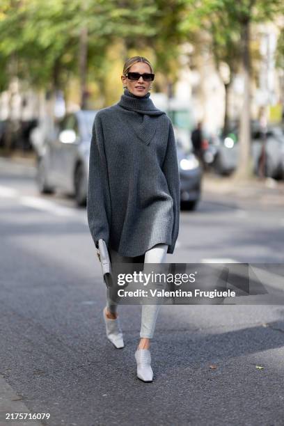 Helena Bordon wears black sunglasses, a grey turtle neck long sweater, grey leggins, a grey leather bag and grey heeled mules outside Zimmermann show...