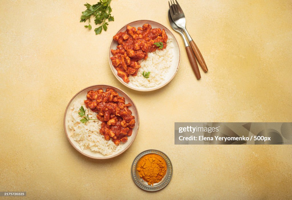 Indian chicken curry served with white rice and turmeric on yellow
