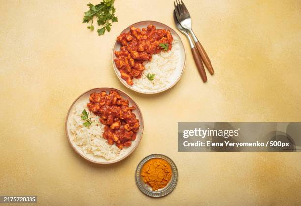 Indian Chicken Curry Served With White Rice And Turmeric On Yellow High-Res Stock Photo