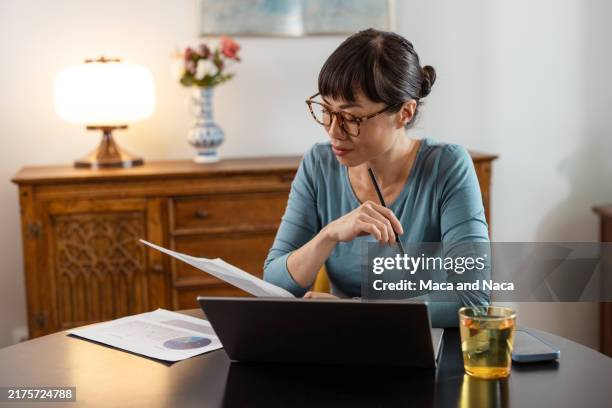 donna giapponese che lavora a casa - occhiali da lettura foto e immagini stock