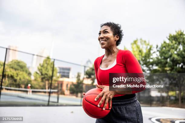 female basketball player shooting free throw on urban basketball court - female basketball team stock pictures, royalty-free photos & images