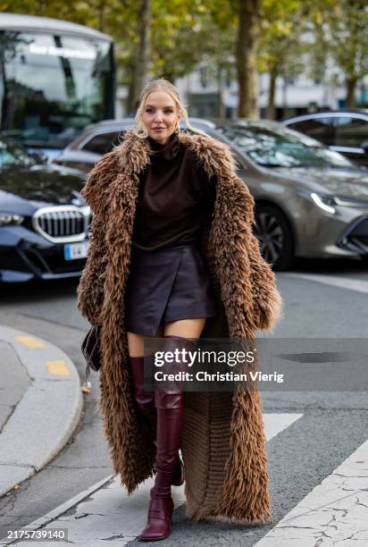 Leonie Hanne wears brown fur coat, grey skirt, burgundy over knees boots outside Stella McCartney during Womenswear Spring/Summer 2025 as part of...