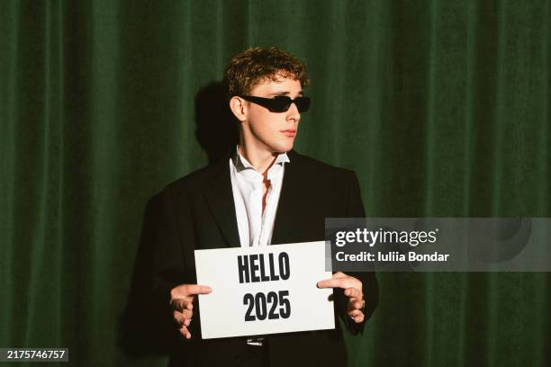 young man holds a 2025 small banner - new year resolution stock pictures, royalty-free photos & images