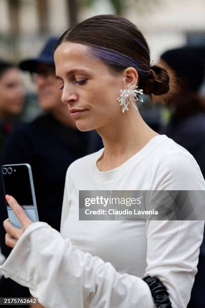 Guest wears white top, white flower earring, outside Rokh, during Womenswear Spring/Summer 2025 as part of Paris Fashion Week on September 30, 2024...