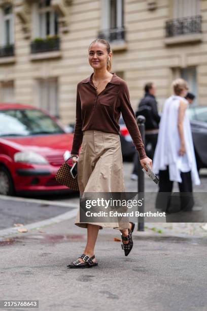 Guest wears dark brown long sleeve shirt, light brown midi skirt, black belted slingback Ganni leather shoes, dark brown pattern bag, outside Stella...