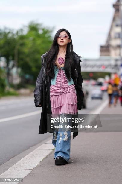 Guest wears transparent sunglasses, black rain coat, dark pink ruffled midi dress with dark pink floral detail, light green cardigan with light brown...