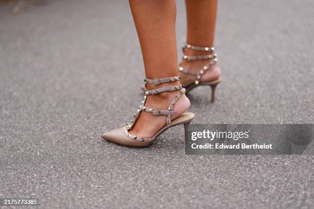 Guest wears light brown pointed toe Valentino Garavani leather strappy gold studded Valentino leather heels, outside Valentino, during the Paris...