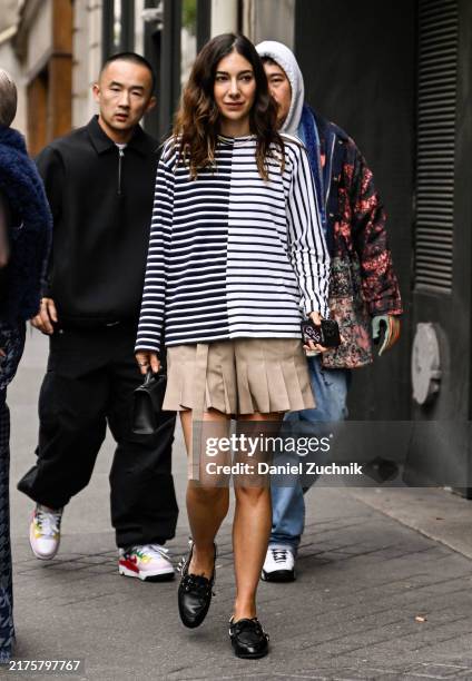 Guest is seen wearing a black and white striped shirt, tan skirt and black shoes sunglasses outside the Sacai show during Womenswear Spring/Summer...