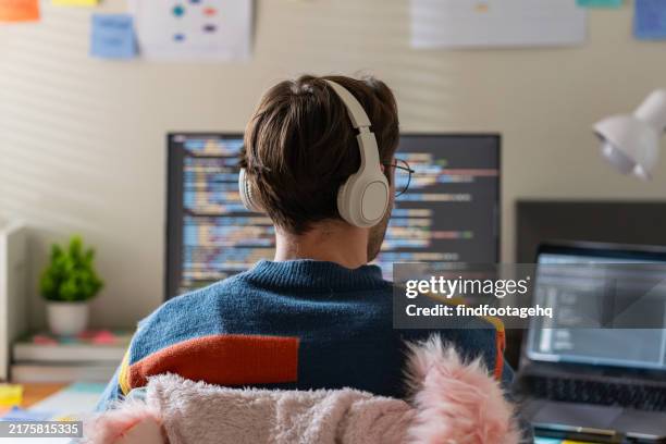 software developer coding at dual monitor setup. - application programming interface stockfoto's en -beelden