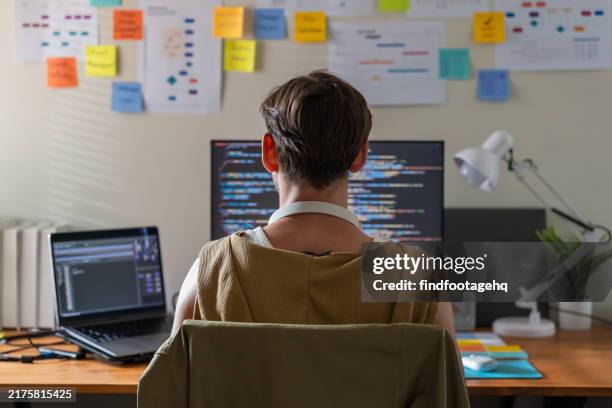 programmer coding at desk in home office. - python data stock pictures, royalty-free photos & images