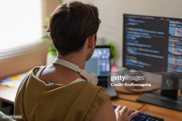 young programmer working on code in a modern home office. - application programming interface stockfoto's en -beelden