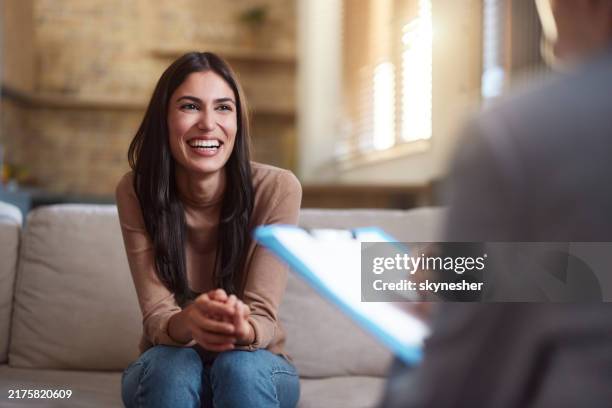 mujer feliz hablando con su terapeuta en casa. - profesional de salud mental fotografías e imágenes de stock