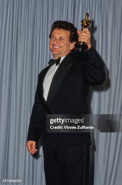 American actor Joe Pesci smiles as he holds up his trophy at the 63rd Annual Academy Awards ceremony, Los Angeles, California, March 25th 1991. He...