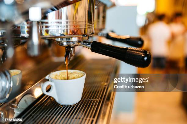 kaffee, der in einem café in eine tasse gegossen wird - coffee shop stock-fotos und bilder