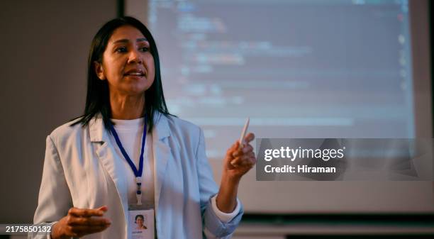 selbstbewusste dozentin, die eine programmiervorlesung bei schlechten lichtverhältnissen im klassenzimmer hält - professor stock-fotos und bilder