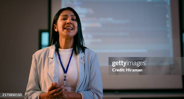 confident female instructor leading multi ethnic stem coding lecture in low light setting - projection equipment stock pictures, royalty-free photos & images