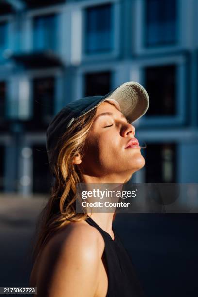 woman enjoying sun with eyes closed - anywhere but here stock pictures, royalty-free photos & images