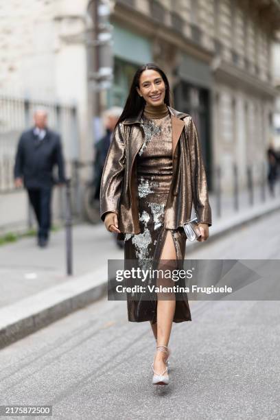 Guest wears a brown paillettes jacket, a brown and silver turtle neck paillettes midi skirt, a silver bag and silver pumps outside Akris show during...