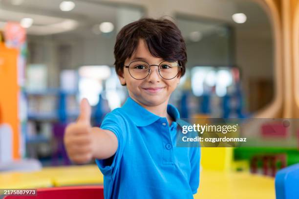 cute little boy with glasses in the library - 4 5 years stock pictures, royalty-free photos & images