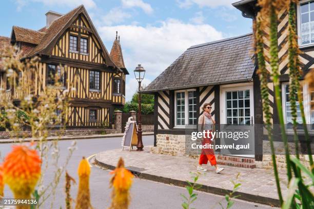 woman exploring beuvron-en-auge village normandy france - normandy stock pictures, royalty-free photos & images