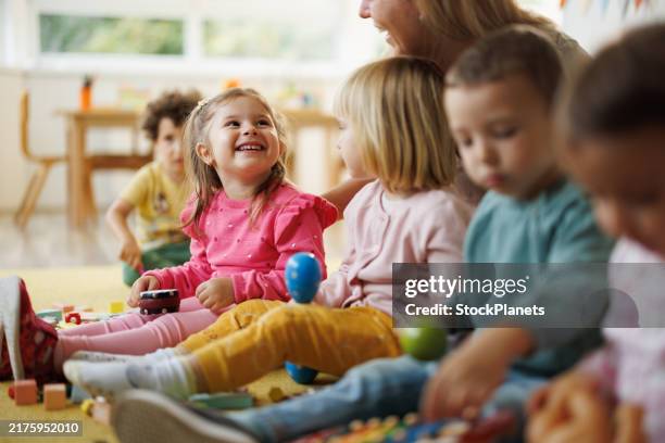children explore music through instruments in the nursery - cuidar de crianças imagens e fotografias de stock