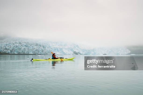 frau kajakfahren an einem gletscher in alaska - reiseführer stock-fotos und bilder