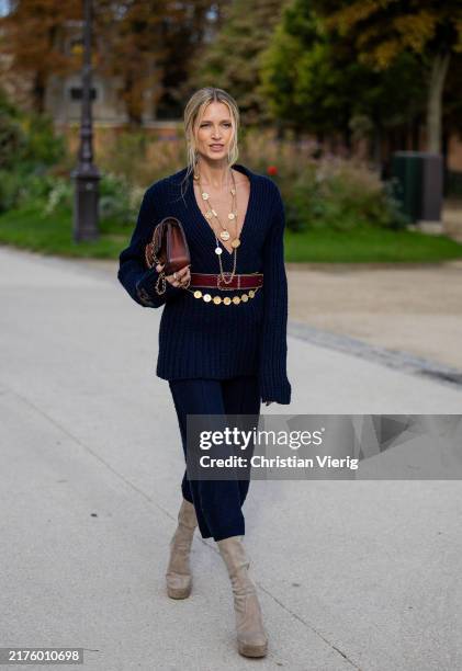 Helena Bordon wears hair band with logo navy knit, brown bag, suede boots in grey outside Chanel during Womenswear Spring/Summer 2025 as part of...