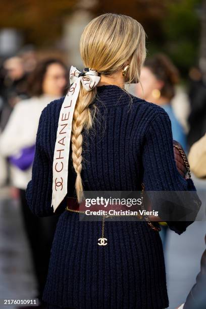 Helena Bordon wears hair band with logo navy knit, brown bag outside Chanel during Womenswear Spring/Summer 2025 as part of Paris Fashion Week on...